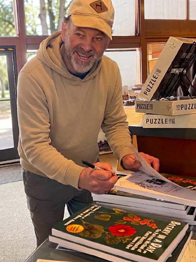 Author Thomas J. Elpel signing books at a national park visitor center.